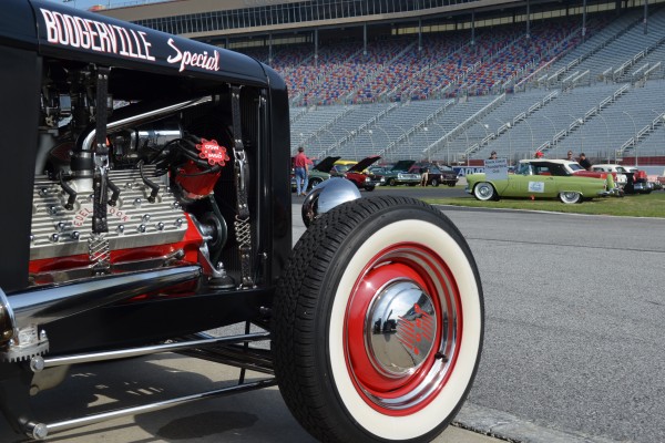 classic car show with a black hot rod wheel in the foreground