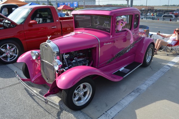 pink panther plush toy behind the wheel of a vintage hot rod coupe