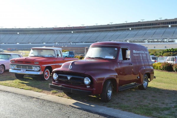 a pair of vintage trucks at a large car show