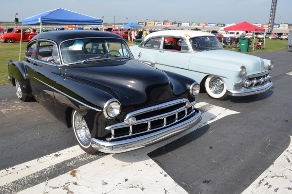 an old Cadillac and gm coupe parked at a classic car show