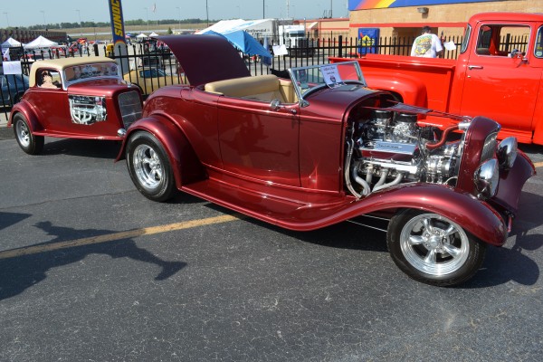 a vintage ford roadster hotrod pulling a matching custom trailer
