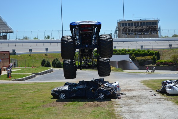 bigfoot monster truck leaping over crushed cars