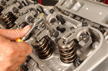 man adjusting rocker arms on a big block chevy cylinder head