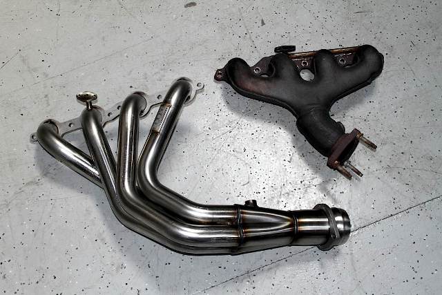 a set of headers and exhaust manifold on a garage floor