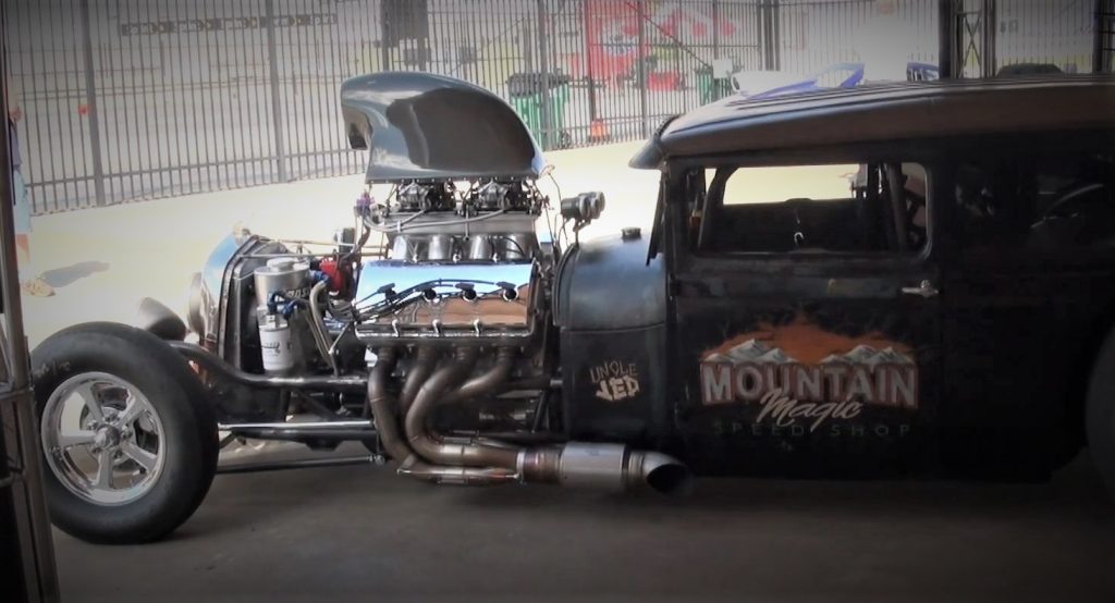 man starting up an old ford hot rod at a show