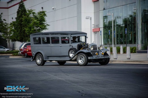 vintage prewar motor coach bus entering a car show