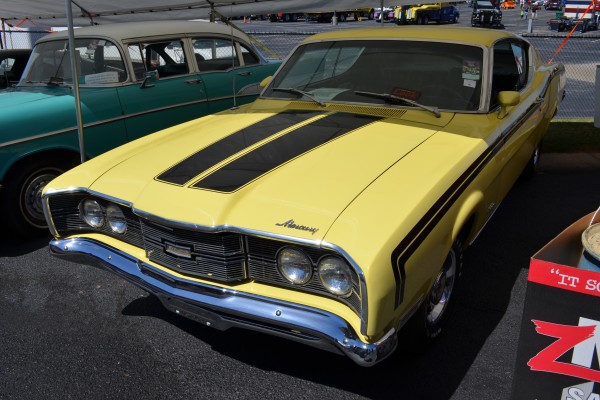 vintage mercury cyclone muscle car under an awning tent
