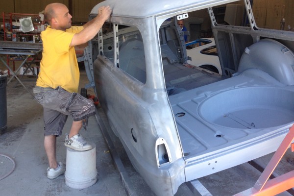 a man sanding the roof of a vintage car prior to paint