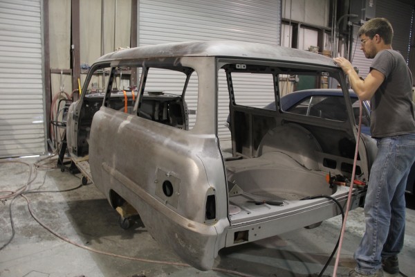 a man grinding down body imperfections during a car restoration