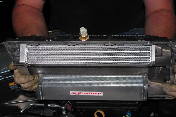 man holding an air-to-air intercooler for a supercharged engine