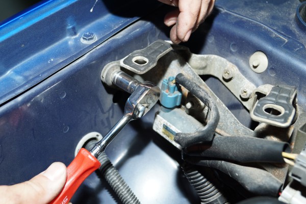 removing a bracket in the engine bay of a car