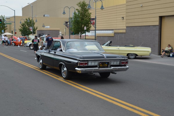 vintage plymouth sport fury coupe from the 1960s driving on city street