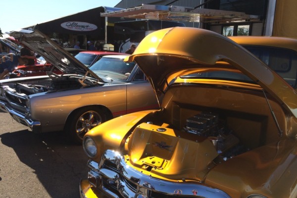 row of classic car displays at a large car show