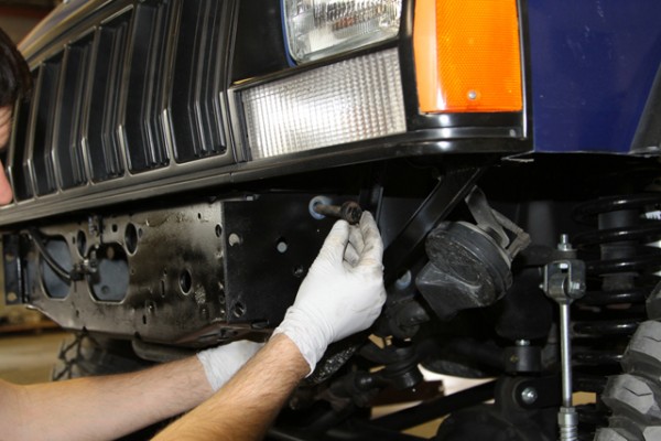 Man threading bolt into Jeep Cherokee XJ Bumper mount