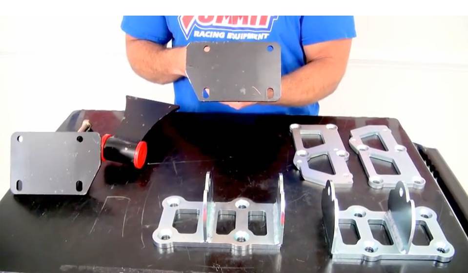 man holding engine mounts on a table