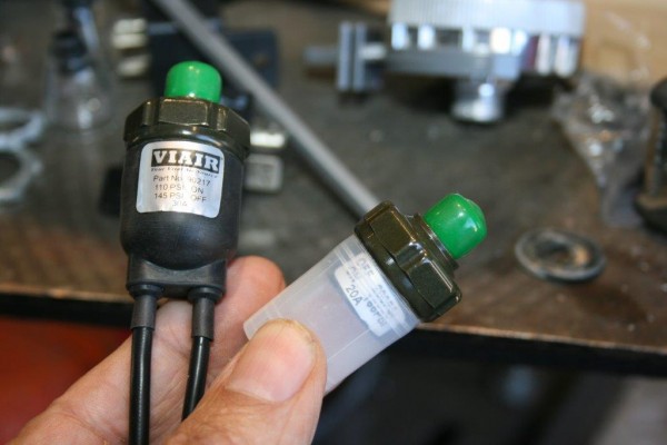 man holding a pair of air pressure switches