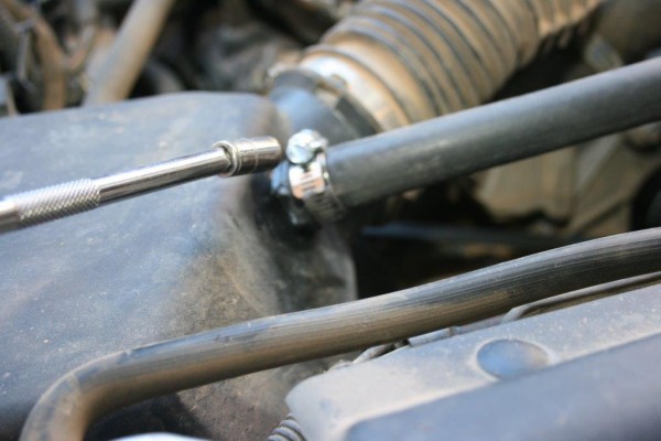 tightening a heater hose clamp on an engine