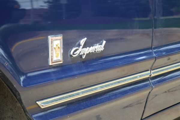 close up of the fender emblem badge on a 1967 Chrysler Imperial