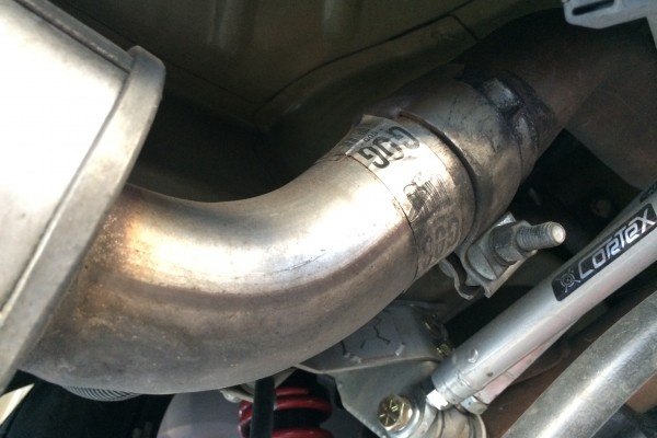 a ford mustang muffler clamped on an exhaust pipe