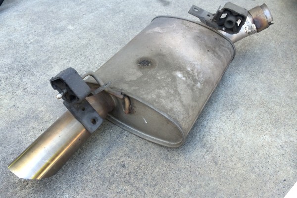 a car muffler resting on the ground