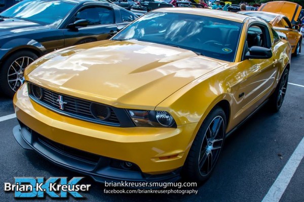 yellow ford mustang s197 at a car show