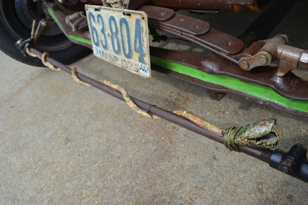 a fake snake wrapped around the steering rack of a rat rod
