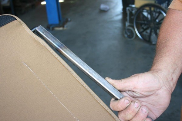 man bending hinge rod on a jeep cj soft door frame