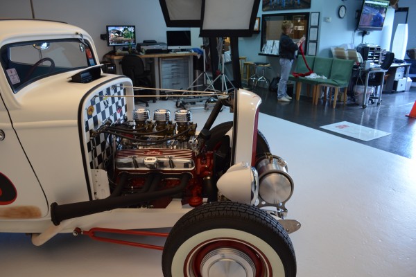 front of a chevy powered ford hot rod in a photo studio
