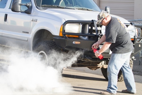 man putting out a small fire with a handheld extinguisher