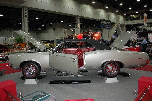 silver Pontiac GTO convertible on display in indoor car show