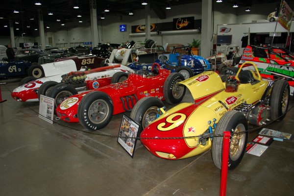 row of vintage race cars on display in indoor car show