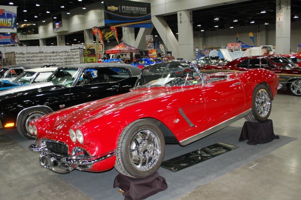red 1962 chevy corvette restomod on display in indoor car show