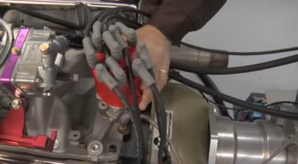 man adjusting engine ignition timing on a distributor