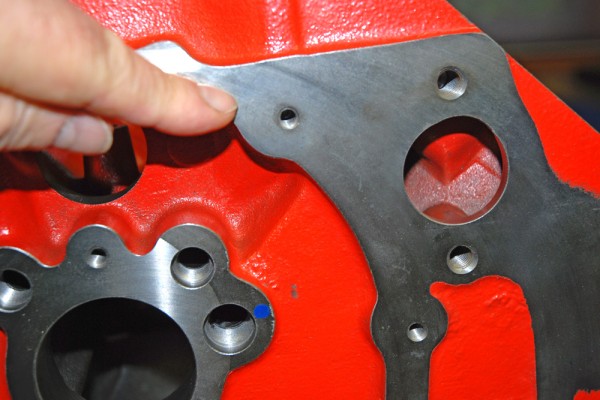 man pointing to timing cover mounting pad on an engine