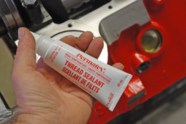 man holding a tube of permatex thread sealant