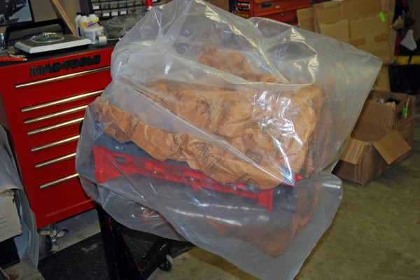 An engine block on a stand covered in plastic bag