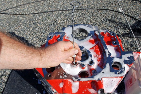 Using a scrub brush to clean engine passages