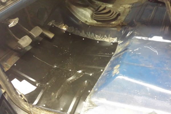 sheetmetal riveted to the floor of a rusted out ford bronco