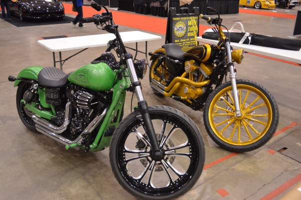 a pair of customized motorcycles at an indoor car show