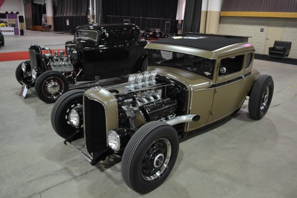 pair of hotrod coupes at a car show