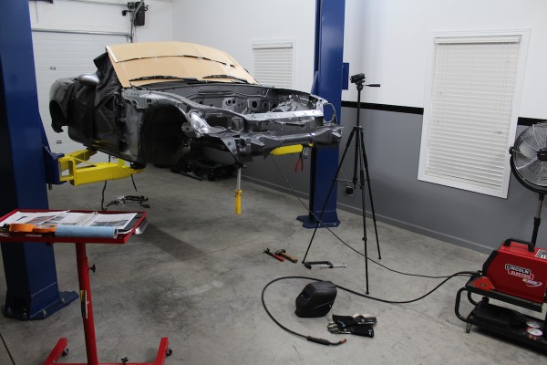 mazda miata ls swap project car on a 2 post lift in a shop