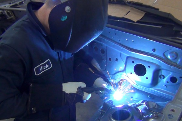 man welding chassis braces for an ls swap miata project