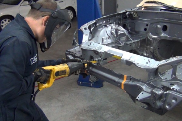man sawing through bumper on a mazda miata