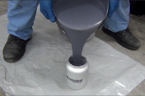 pouring lizardskin into a spray gun cup