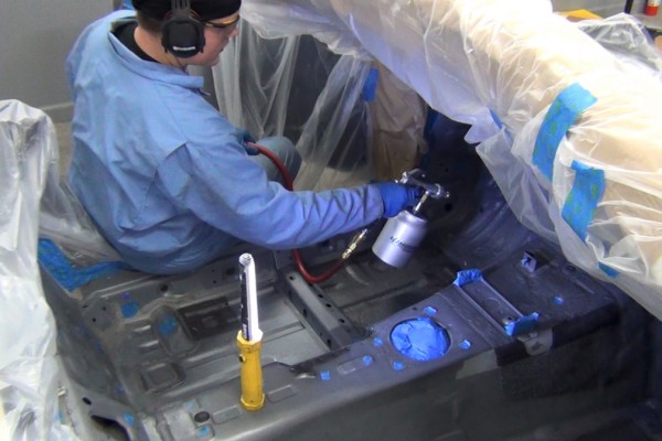 spraying lizardskin coating into a vehicle floor