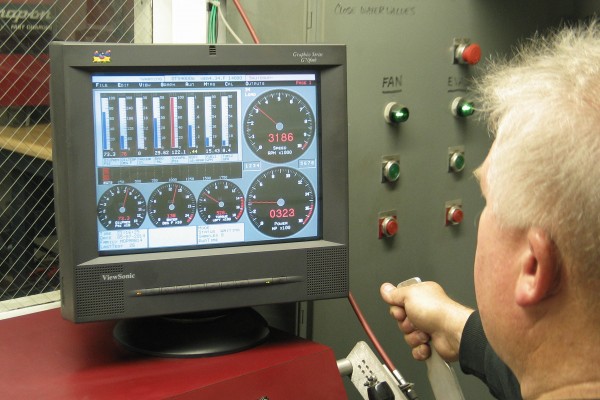 man watching computer screen on engine diagnostics during dyno run