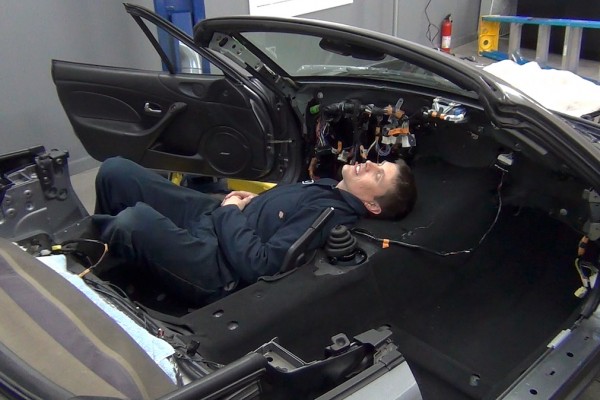 man running wire in a miata prior to an LS enigne swap