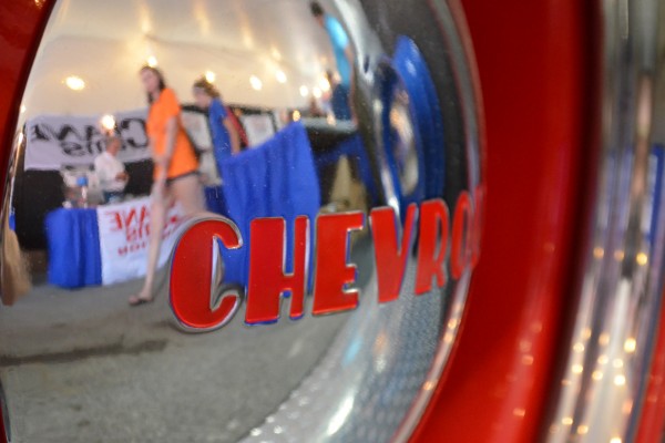 chevy hubcap with reflections of people walking by