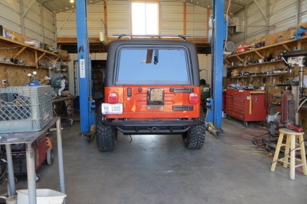 jeep wrangler TJ in a shop with a lift