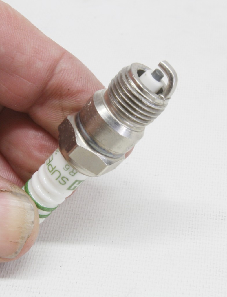 Man holding an automotive spark plug
